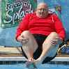 толстый человек прыгает в воду